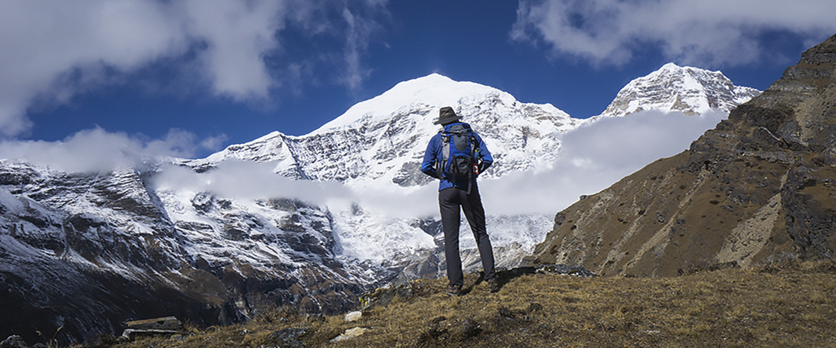 Trekker back to camera in front of Jomolhari large Himalayan Peak Bhutan